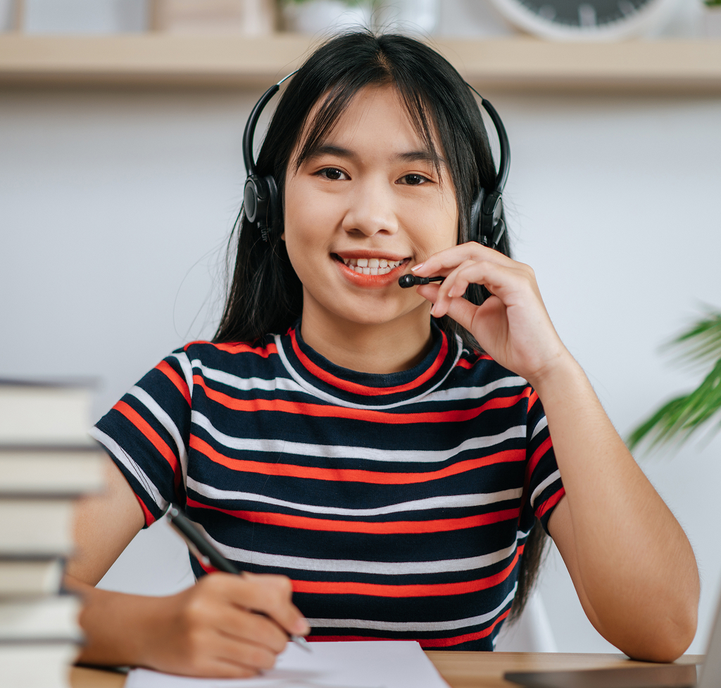 Offshore professional woman reading documents at her desk wearing headphones